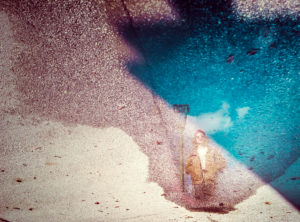 Austria, Mondsee, reflection of young man in puddle