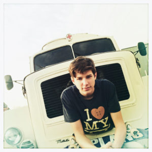 boy sitting on an old truck and holding a skateboard, harbour Hamburg