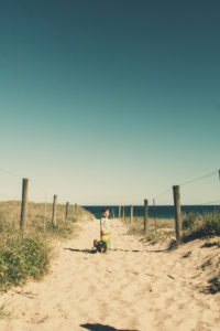 Boy walking to the beach with toys, Cronulla, New South Wales, Australia