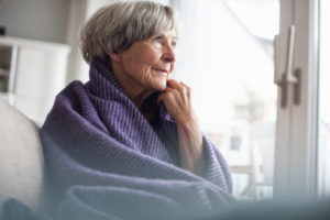 Portrait of pensive senior woman sitting on couch at home Portrait of pensive senior woman sitting on couch at home