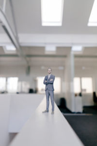 Businessman figurine standing on desk in modern office