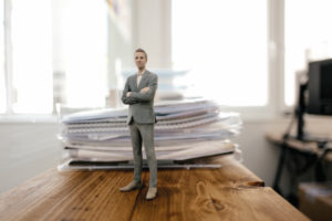 Businessman figurine standing on desk with files