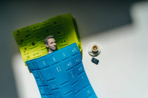 Businessman figurine taking a nap under keyboard blankets