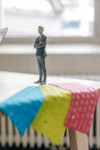 Businessnessman figurine standing on desk with tablet keyboards