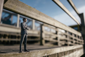 Businessman figurine standing on wooden stairs