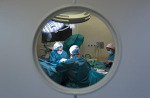 Surgeons and nurse during a surgery behind the door