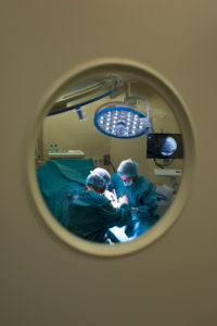 Surgeons during a surgery behind the door
