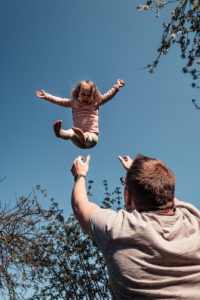 Father throwing little daughter up in air Father throwing little daughter up in air
