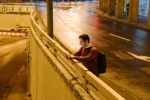 Businessman with backpack taking selfie with smartphone at night, Frankfurt, Germany Businessman with backpack taking selfie with smartphone at night, Frankfurt, Germany