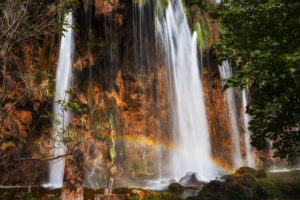 Croatia, Small rainbow over splashing waterfall in Plitvice Lakes National Park Croatia, Small rainbow over splashing waterfall in Plitvice Lakes National Park