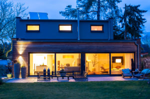 Illuminated house with furniture in back yard at dusk Illuminated house with furniture in back yard at dusk