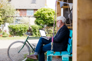 Senior man sitting outdoors looking at laptop Senior man sitting outdoors looking at laptop
