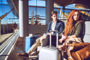 Thoughtful business couple waiting at airport departure area Thoughtful business couple waiting at airport departure area