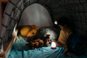Girl scout playing with globe and stuffed toys in darkroom Girl scout playing with globe and stuffed toys in darkroom