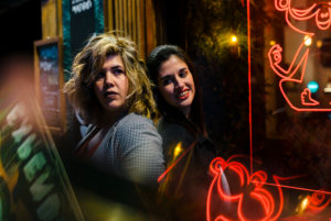 Lesbian couple looking at cafe window Lesbian couple looking at cafe window