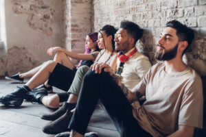 Group of friends sitting on the floor in a loft Group of friends sitting on the floor in a loft