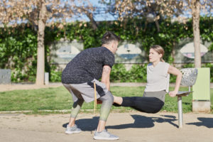 Woman during work out with coach in park Woman during work out with coach in park