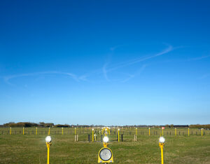 Runway at Leeuwarden airforce base with contrails from a NATO exercise in the sky