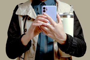 Cropped view of a person holding a smartphone and a water thermos