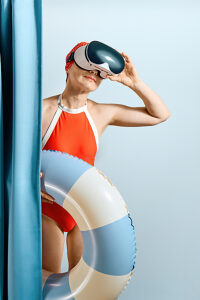 Woman in red swimsuit with VR headset and swimming ring indoors