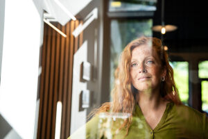Businesswoman with red hair looking through office window