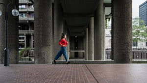 Woman running in urban brutalist architecture setting