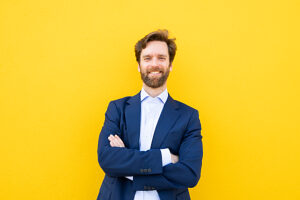 Businessman smiling against yellow background