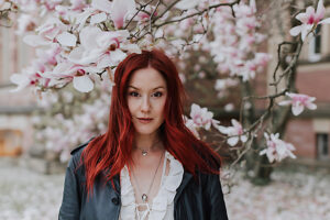 Woman with red hair among blooming magnolias