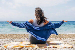 Woman enjoying freedom at the beach with open arms