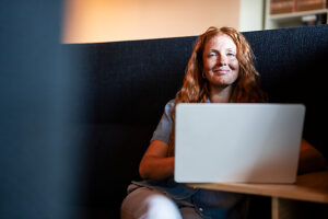 Red-haired woman working on laptop in modern office