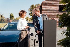 Business team charging electric vehicle outdoors