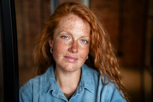 Confident red-haired woman with freckles at the office