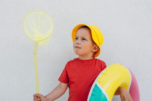 Child holding net and rubber ring in summer attire