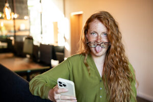 Woman with sunglasses making a funny face in an office