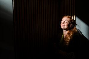 Red-haired woman relaxing in sunlight at office