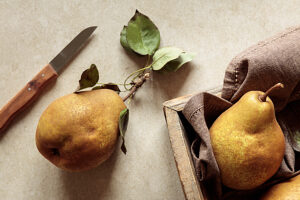 Brown pears and knife on rustic countertop in studio setting
