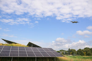 Solar panels near airfield with airplane in sky in Rotterdam the Netherlands