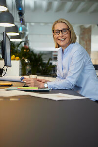 Businesswoman showing leadership and optimism at modern office desk