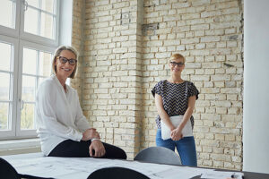 Smiling colleagues working together in a modern office with brick wall