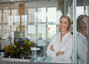Businesswoman smiling with arms crossed in modern office