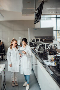 Scientists examining data on tablet in modern medical laboratory