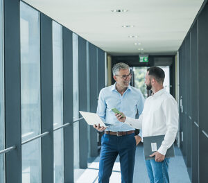 Business colleagues communicating in modern office hallway