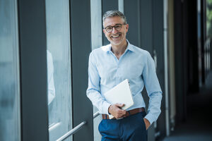 Professional portrait in modern office with notebook and smiling expression
