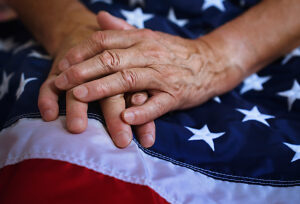 Close up of elderly hand resting on American flag showing patriotism