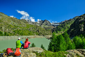 Couple enjoying mountain lake view in Bernina Alps Lombardy Italy