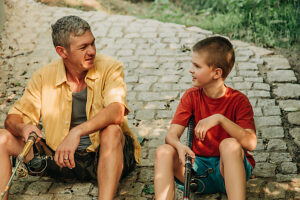 Father and son fishing on river bank in autumn spending time together