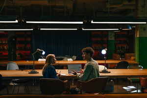 Colleagues discussing work at a laptop in a modern coworking office