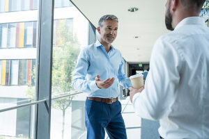 Business colleagues discussing in modern office hallway