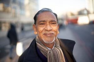 Smiling man in winter clothing outdoors on London street in sunlight