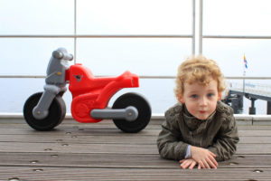 Usedom, Ahlbeck pier, boy with toy motorbike Usedom, Ahlbeck pier, boy with toy motorbike